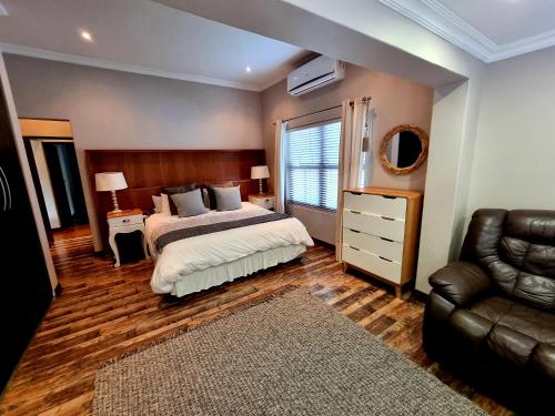 a bedroom with a bed and a couch and a chair at 391 Vaal de Grace Golf Estate, Parys in Parys