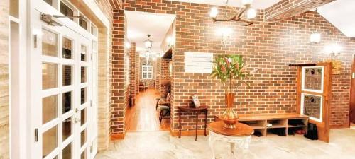 a room with a brick wall with a vase on a table at 墾丁勿忘我城堡莊園 in Hengchun