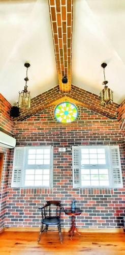 a brick wall with a table and a stained glass window at 墾丁勿忘我城堡莊園 in Hengchun