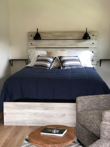 a bedroom with a blue bed and a couch at Cabin 3 at Horse Creek Resort in Rapid City
