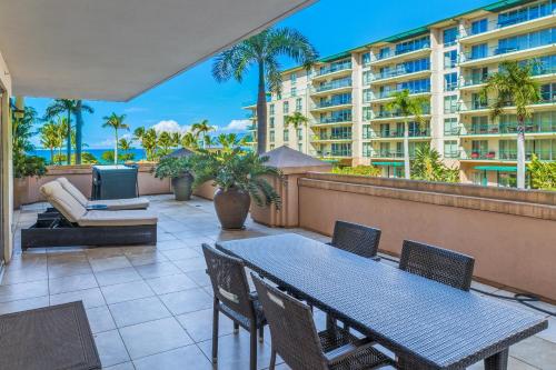 a patio with a table and chairs and a building at Honua Kai 215 2 Bedroom 2 Bath condo in Lahaina
