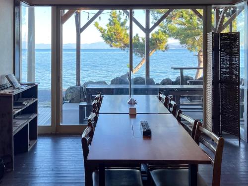 a table in a room with a view of the ocean at Biwa-Lakeside Cottage B B Dylan in Minami-komatsu