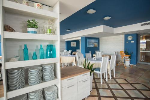 a dining room with a table with plates and blue vases at Smartline Meridian Hotel in Sunny Beach
