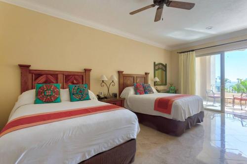 1 dormitorio con 2 camas y balcón en Beachfront Resort Living at Villa La Estancia, en Cabo San Lucas