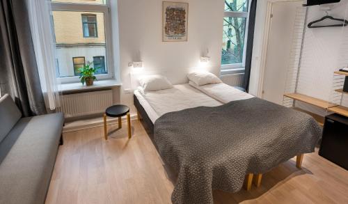 a bedroom with a bed and two windows at Go Hotel Ansgar in Copenhagen
