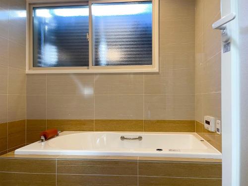 a bath tub in a bathroom with a window at Biwa-Lakeside Cottage B B Dylan in Minami-komatsu
