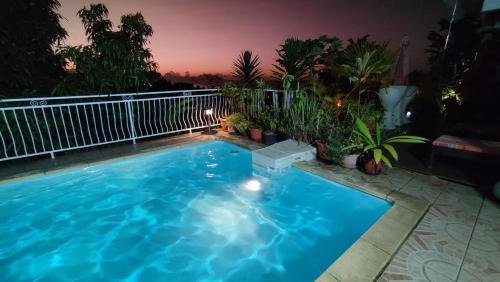 a large blue swimming pool on a balcony at night at Manava Tahara'a Home Stay in Mahina