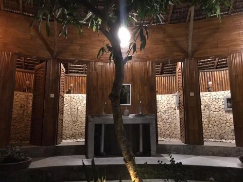 a building with a palm tree in the foreground at Gading Tree House in Nusa Penida