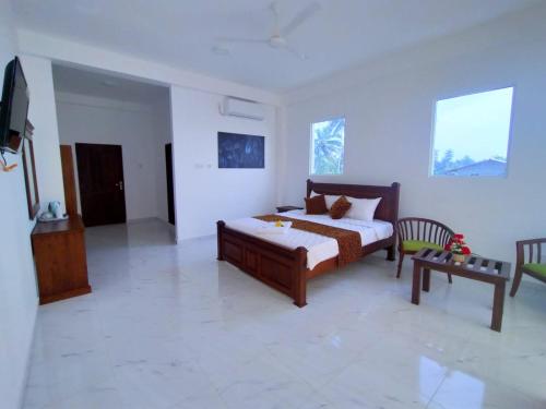 a bedroom with a bed and a table in it at Bivon Reach in Uswetakeiyawa