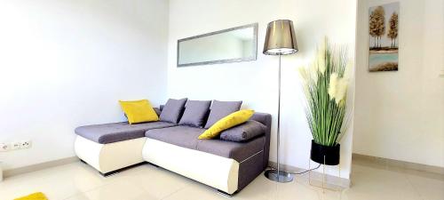 a living room with a couch and a lamp at Apartment Seaside Mireja in Kaštela