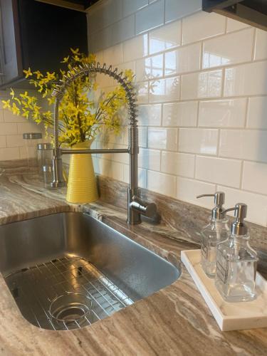 a kitchen sink with a vase of flowers on a counter at Cozy, Upstairs Apartment Pets Welcome with fee Family Friendly Close to Everything in Cleveland
