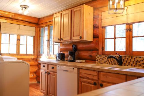 a kitchen with wooden cabinets and a white refrigerator at Historic Log Cabin #14 at Horse Creek Resort in Rapid City