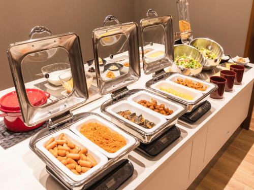 a buffet with several trays of food on a table at Sotetsu Fresa Inn Daimon in Tokyo