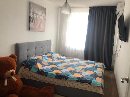 um quarto com uma cama e um ursinho de peluche em Шикарный вид на Днепр em Dnipro