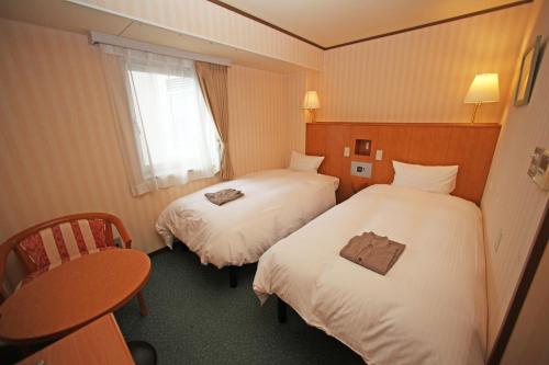 Un pat sau paturi într-o cameră la Hotel Prime inn Toyama