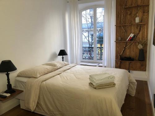una camera da letto con un letto e due asciugamani di PARIS SWEET DREAM a Parigi