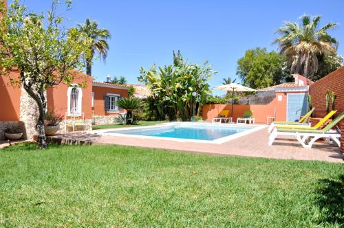 a backyard with a swimming pool and a house at Fantastic Private Villa ideal for great family holidays in Quarteira