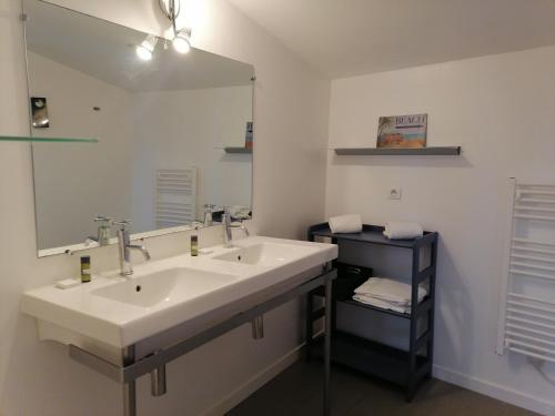 une salle de bain avec un lavabo et un grand miroir dans l'établissement La Longère des Olonnes, à Les Sables-dʼOlonne