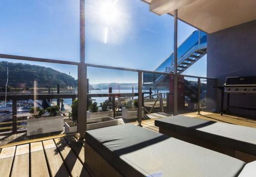 a balcony with benches and a view of the water at Riverfront Dream on the Hawkesbury - Water View in Brooklyn
