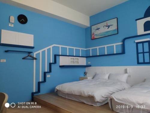 后里區的住宿－和和旅宿，一间蓝色的卧室,配有两张床和楼梯