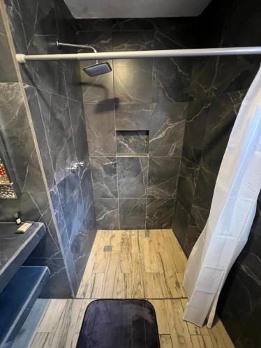 a bathroom with a shower with a wooden floor at Casa Dos Fridas - Centro Guanajuato in Guanajuato