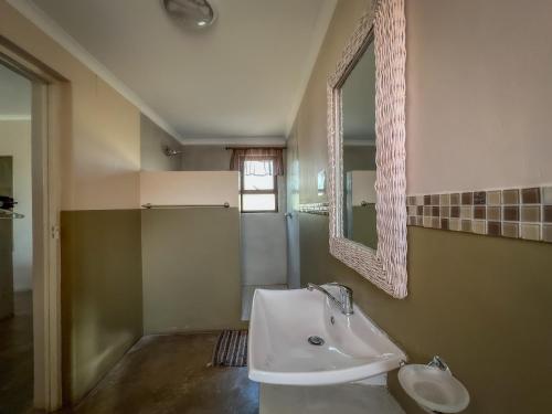 a bathroom with a sink and a mirror at Uukwaluudhi Safari Lodge in Okahao