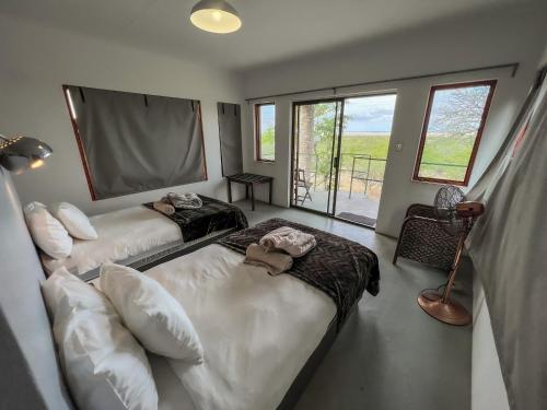 a bedroom with two beds and a window with a view at Uukwaluudhi Safari Lodge in Okahao