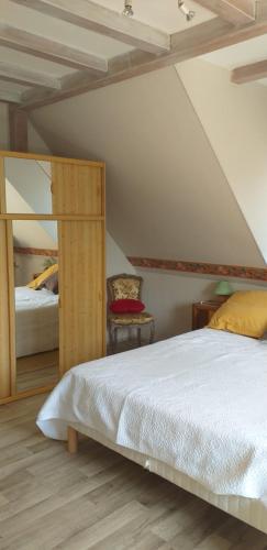 um quarto com uma cama grande e um espelho em CHEZ LE VIGNERON em Westhalten