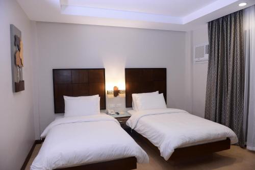 a hotel room with two beds with white sheets at MO2 Lagoon Coron in Coron