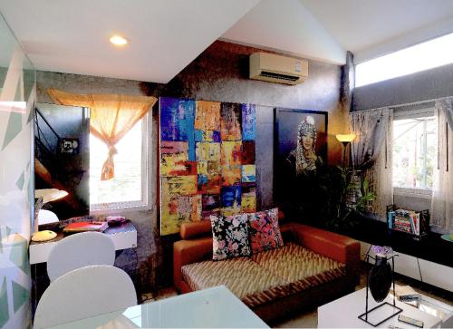 ein Wohnzimmer mit einem Sofa und einem Gemälde an der Wand in der Unterkunft Phuket Paradiso in Chalong 