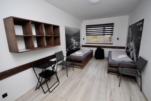 a room with two beds and a table and chairs at Flight Park Javorovy in Třinec