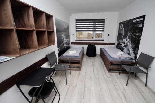 a room with two beds and chairs and a window at Flight Park Javorovy in Třinec