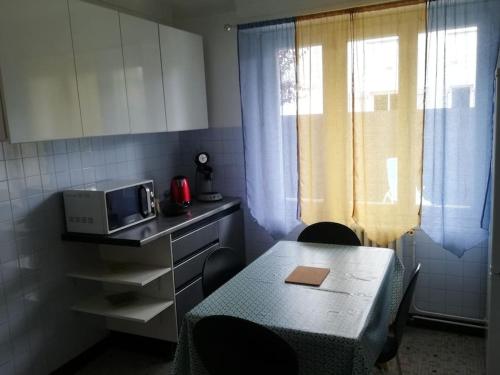 une petite cuisine avec une table et un micro-ondes dans l'établissement Appartement dans Villa, à Pau
