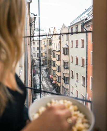 a woman eating food out of a window at Hofgasse Apartments in Innsbruck