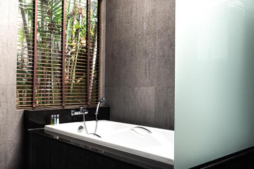 a bathroom with a white tub and a window at Baan Chaweng Beach Resort & Spa - SHA Extra Plus in Chaweng