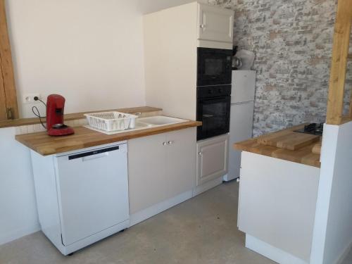 a kitchen with white cabinets and a white refrigerator at l'airial in Souprosse