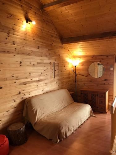 une chambre avec un lit dans une pièce en bois dans l'établissement L’Écrin, à Corps