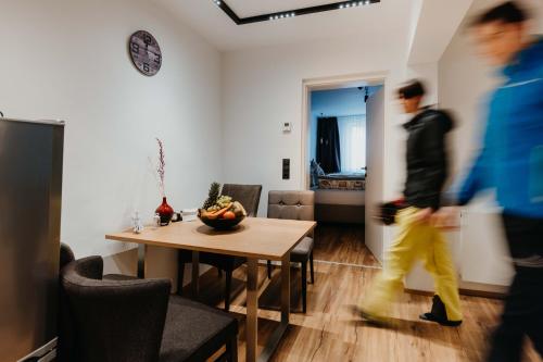 a man walking through a living room with a table at Hofgasse Apartments in Innsbruck