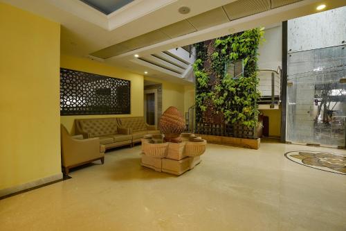 a living room with couches and a plant at FabHotel Phoenix Resorts in Bangalore