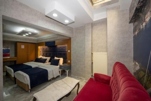 ein Schlafzimmer mit einem großen Bett und einer roten Couch in der Unterkunft Tamara Residence Hotel İstanbul in Istanbul