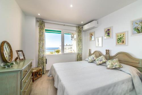 a bedroom with a bed and a window with the ocean at Urbanbeach Imperator in Marbella