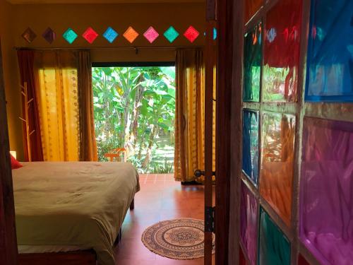 a bedroom with a bed and a door with a window at One World Bungalows in Ko Lanta