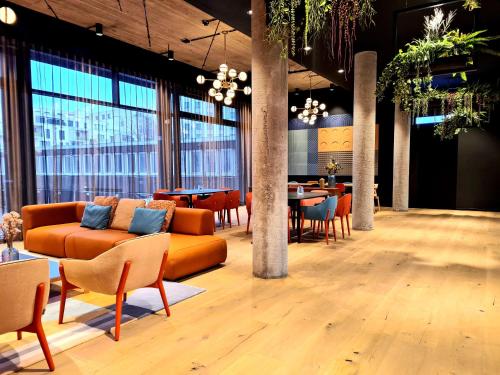 a lobby with a couch and tables and chairs at KONCEPT HOTEL International in Cologne