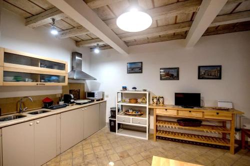a large kitchen with white cabinets and a sink at Casa Clio in Syracuse