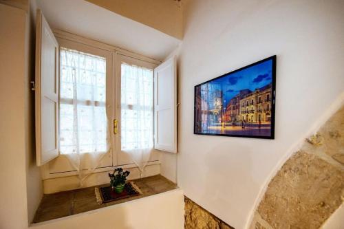 a living room with a television on a wall at Casa Clio in Syracuse