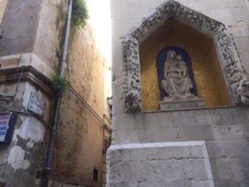 a statue sitting on the side of a building at Casa Clio in Syracuse