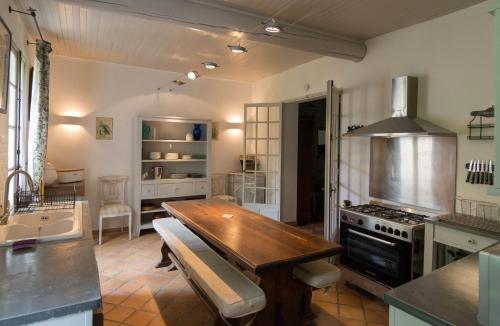 - une cuisine avec une table en bois et une cuisinière dans l'établissement La Marisol, à LʼIsle-sur-la-Sorgue