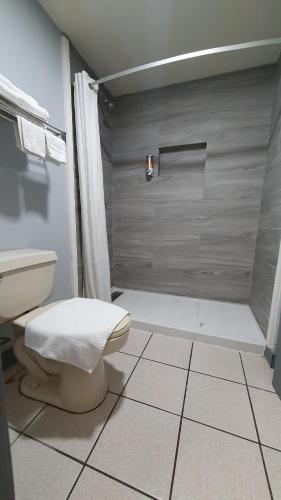 a bathroom with a shower and a toilet in it at South Padre Island Inn in South Padre Island
