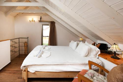 a bedroom with a large white bed in a attic at Vitrage Holiday Village and Spa in Beit Hillel