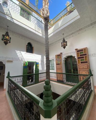 a balcony with a palm tree in a building at Riad Celia in Marrakech